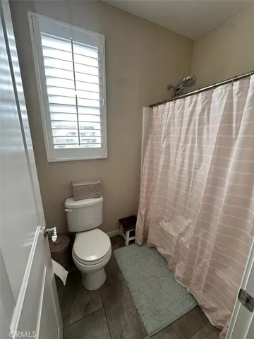 a white toilet sitting next to a shower curtain