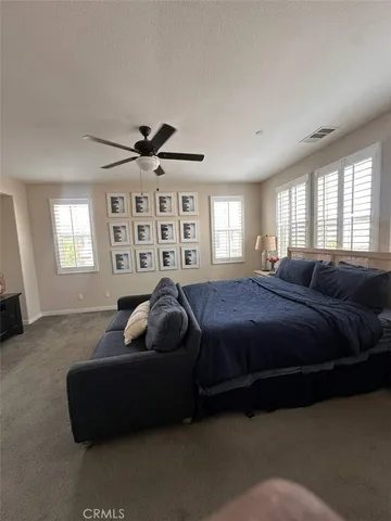 a spacious bedroom with a bed window and couch