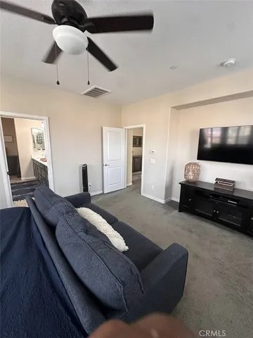 a spacious bedroom with a bed and a flat screen tv