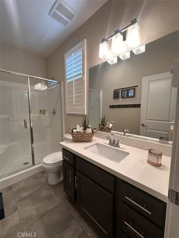 a bathroom with a sink a toilet a large mirror and shower