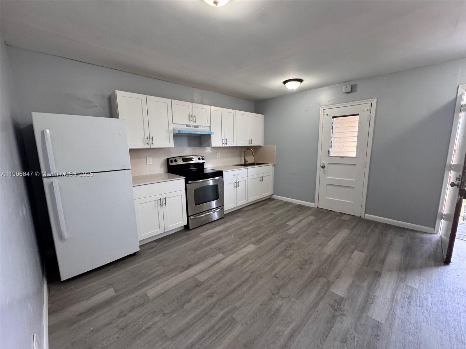 6840 Pembroke Road, Unit 118 Pembroke Pines, FL 33023 - Photo 4 of 7 a kitchen with stainless steel appliances a refrigerator sink and wooden floor