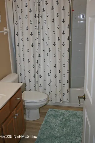 a bathroom with a toilet and a shower curtain