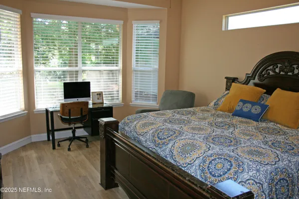 a bedroom with a bed window and a flat screen tv