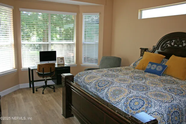 a bedroom with a bed window and a flat screen tv