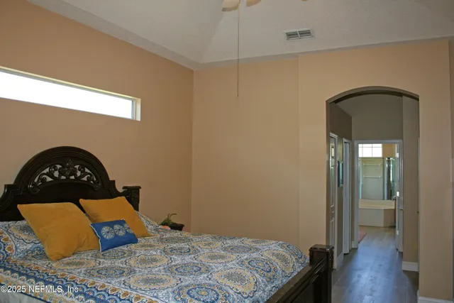 a bedroom with a bed and a painting on the wall