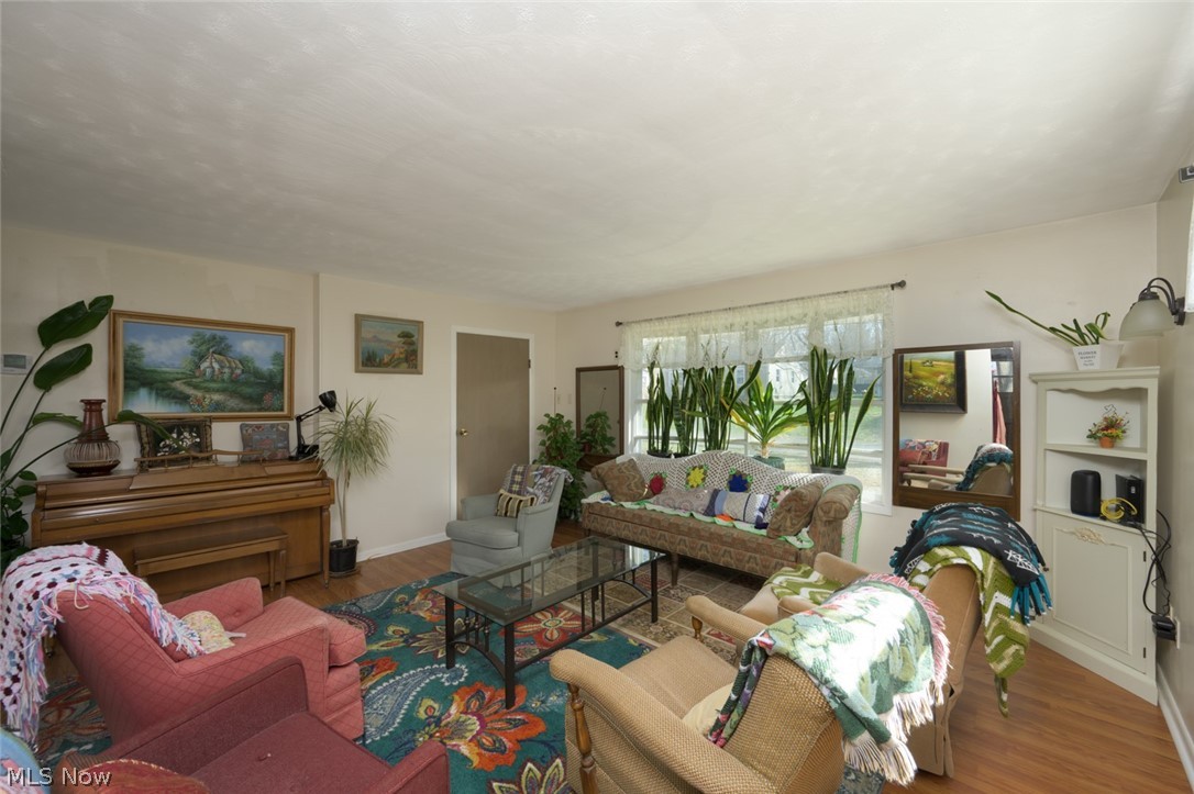 Living room with wood finished floors and baseboards and large bay window