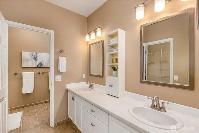 a bathroom with a double vanity sink a mirror and shower