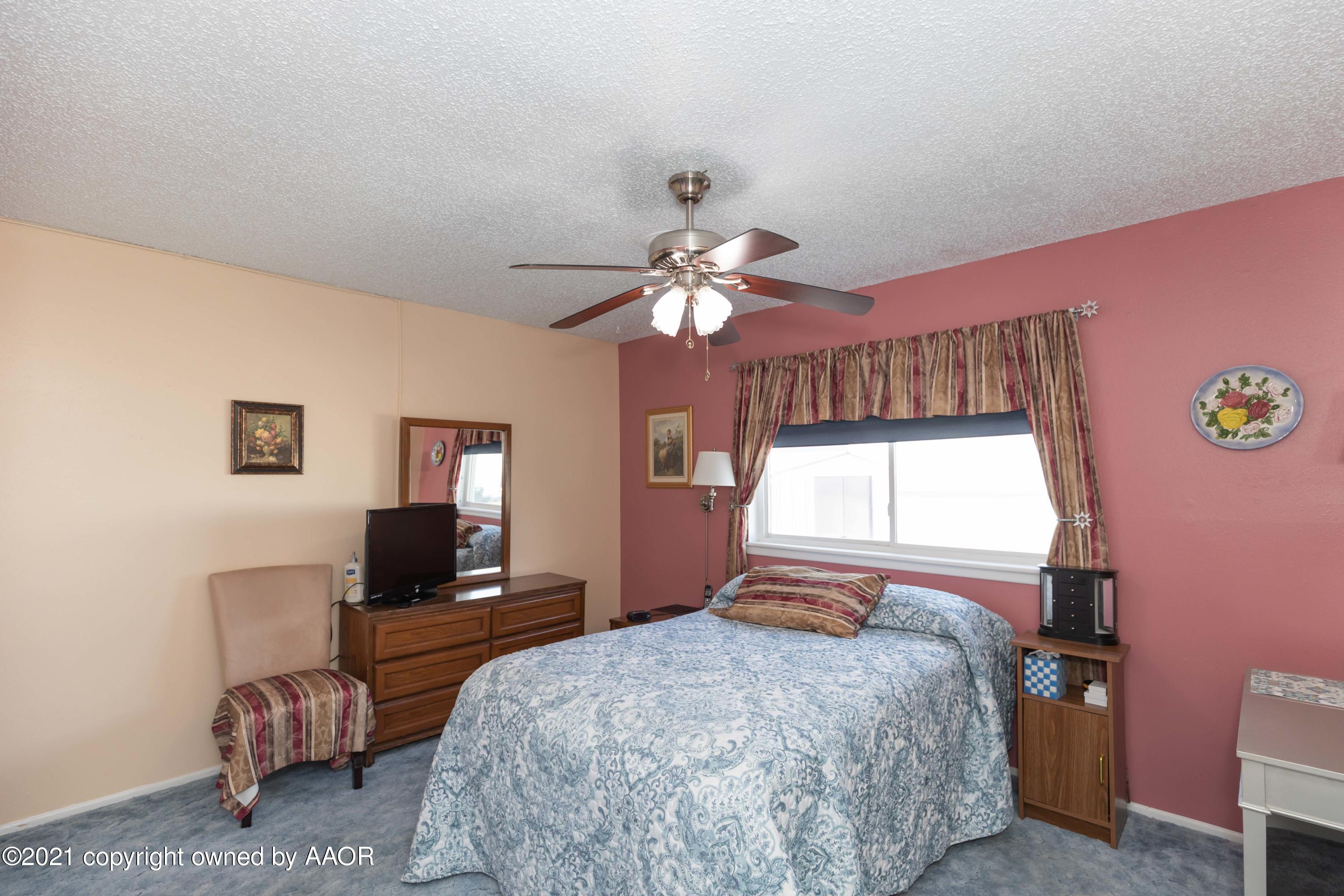 5104 McCarty Boulevard Amarillo, TX 79110 - Photo 14 of 35 a bedroom with a bed and a chandelier