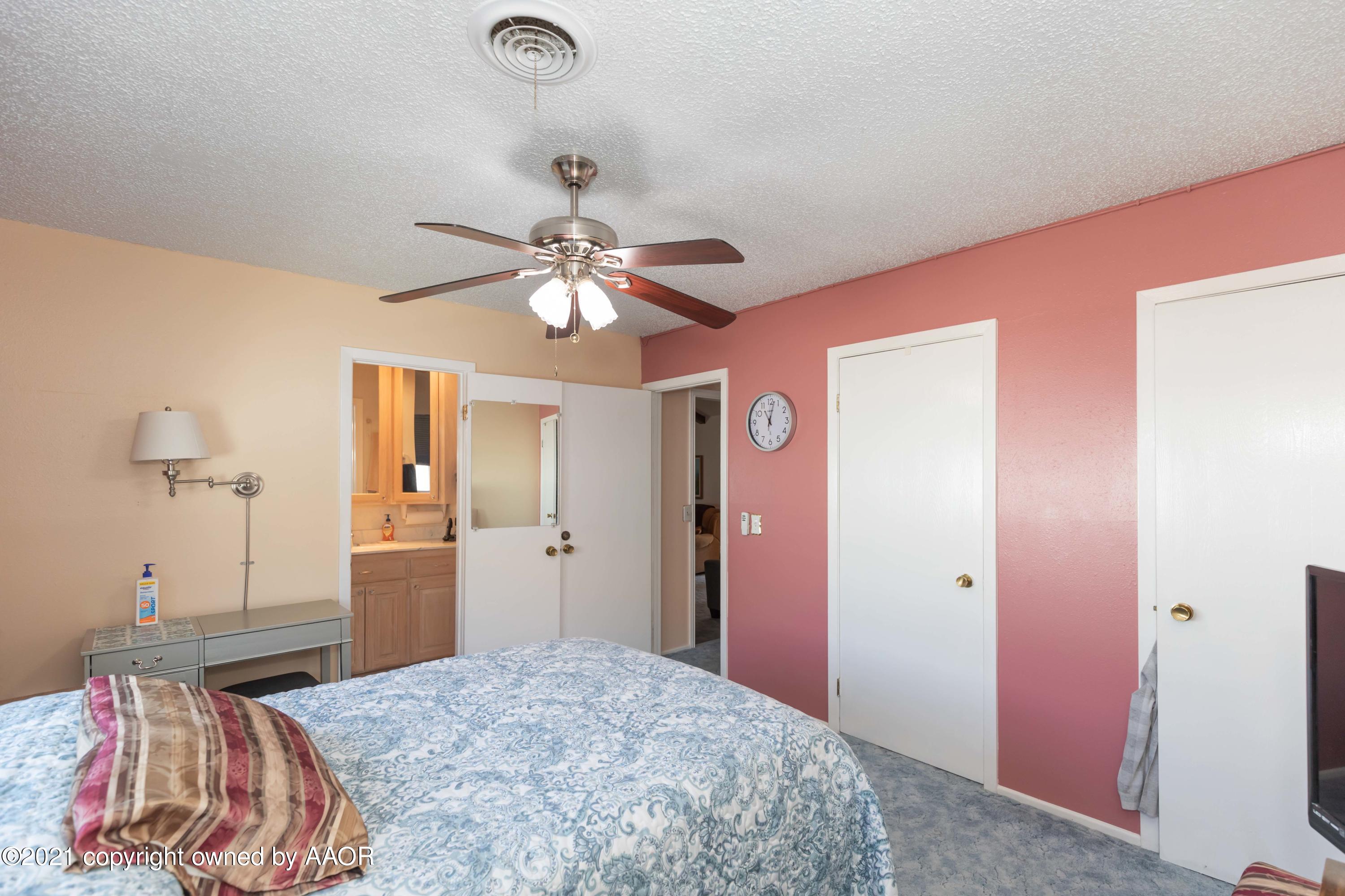 5104 McCarty Boulevard Amarillo, TX 79110 - Photo 16 of 35 a bedroom with a bed and a chandelier