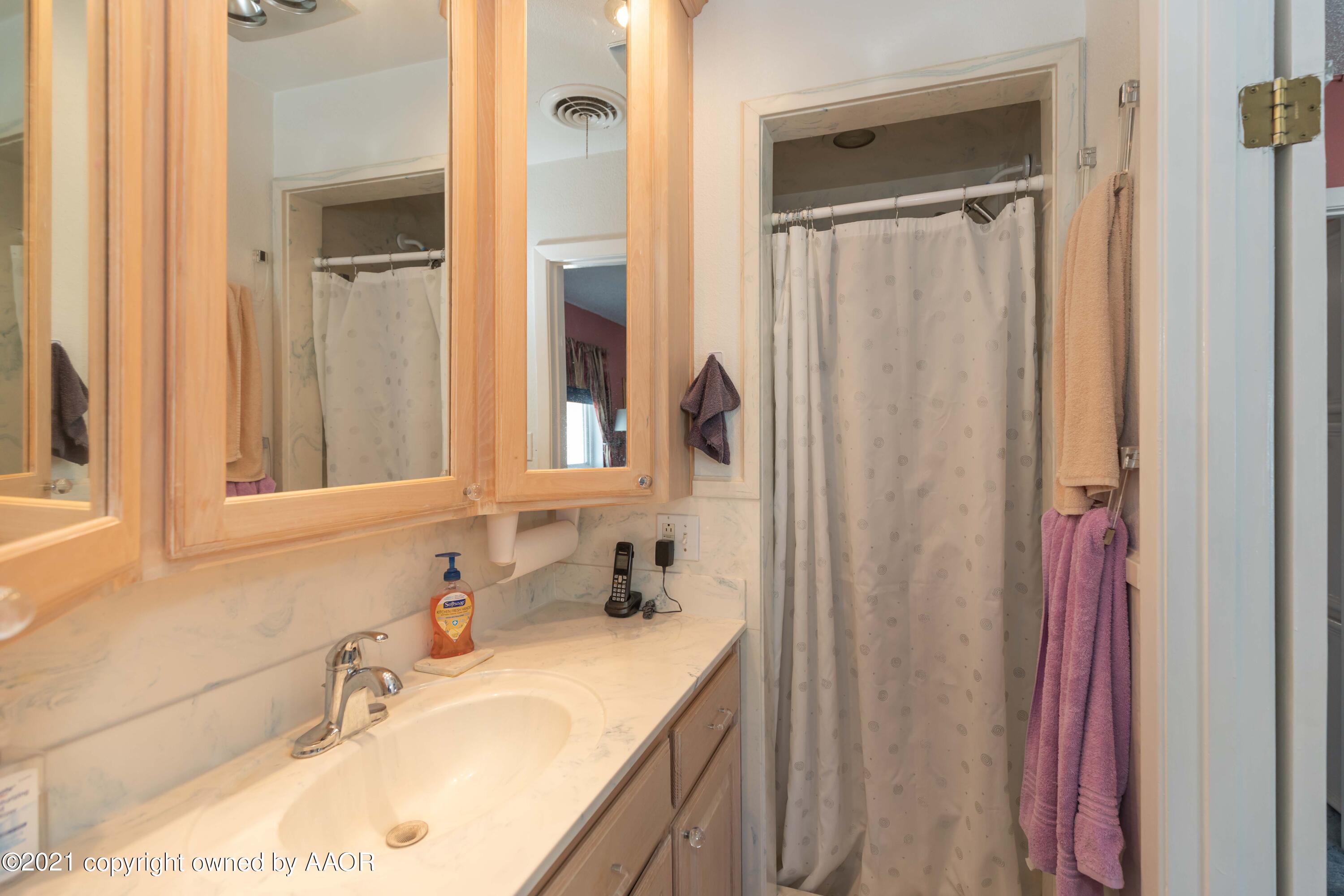 5104 McCarty Boulevard Amarillo, TX 79110 - Photo 17 of 35 a bathroom with a granite countertop sink and a mirror