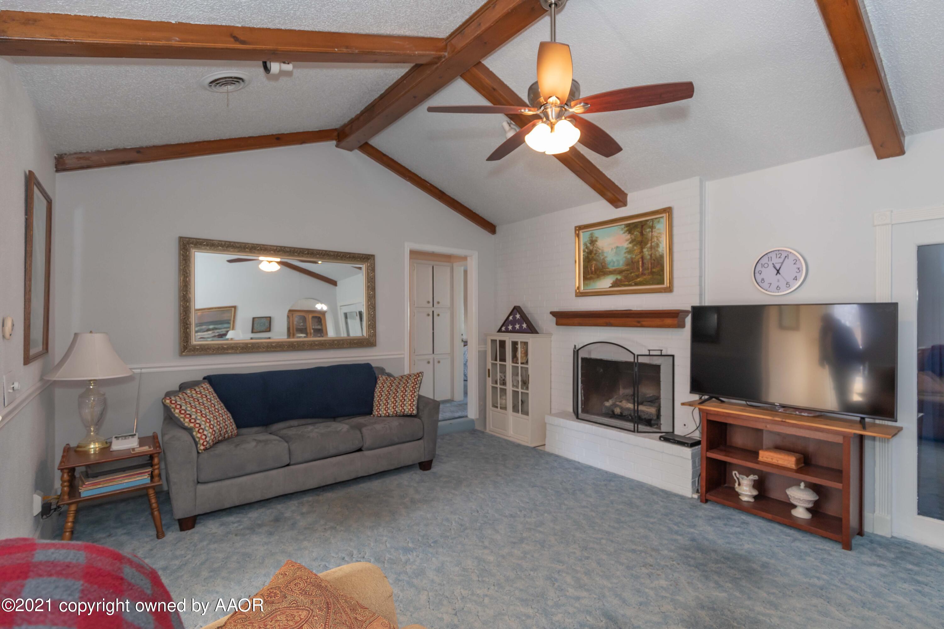 5104 McCarty Boulevard Amarillo, TX 79110 - Photo 6 of 35 a living room with furniture a flat screen tv and a fireplace