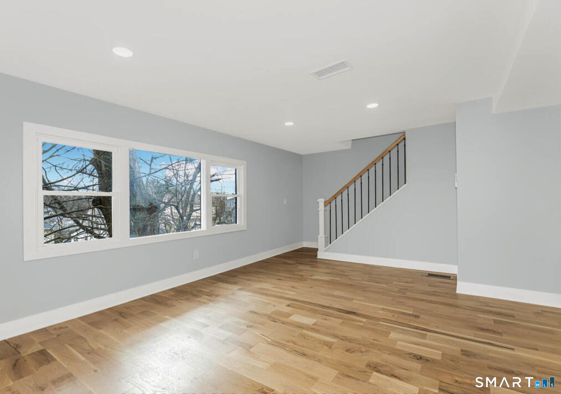 233 Glenbrook Road Stamford, CT 06906 - Photo 6 of 20 a view of an empty room with wooden floor and a window