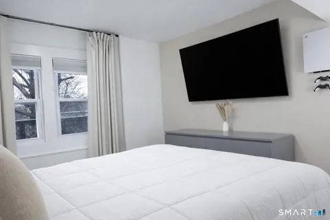 a bedroom with a flat screen tv and a view of bedroom