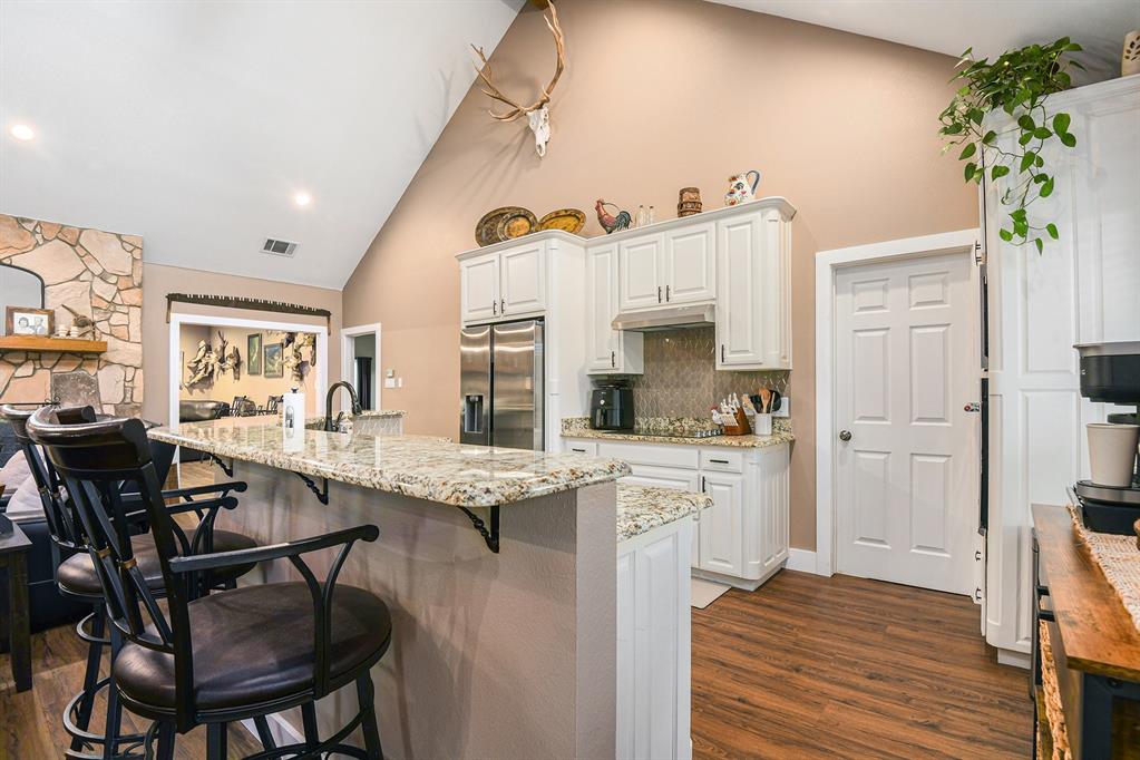 12384 J J Rendon Road Burleson, TX 76028 - Photo 11 of 31 a kitchen with stainless steel appliances granite countertop a table chairs and a refrigerator