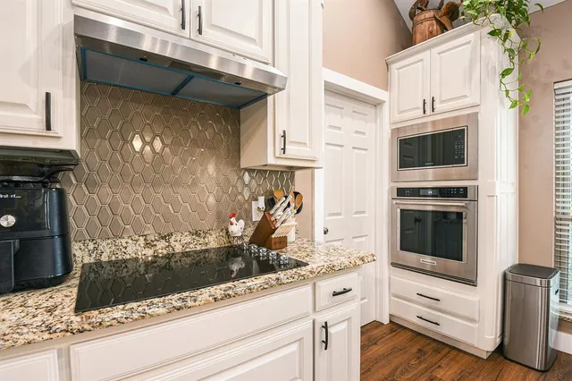 a kitchen with stainless steel appliances kitchen island granite countertop a stove and a microwave