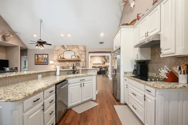 a kitchen with stainless steel appliances granite countertop a sink stove and refrigerator