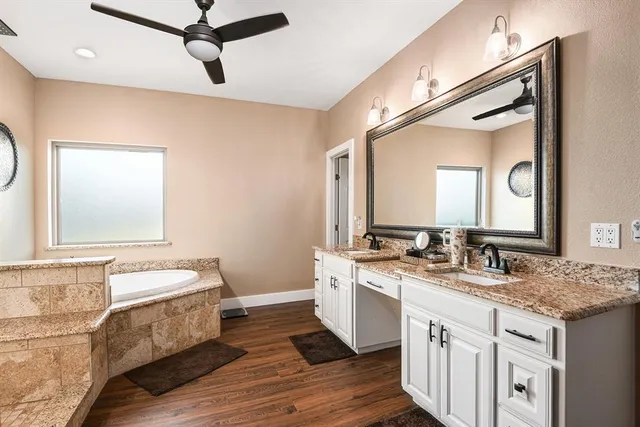 a bathroom with a tub sink shower and mirror