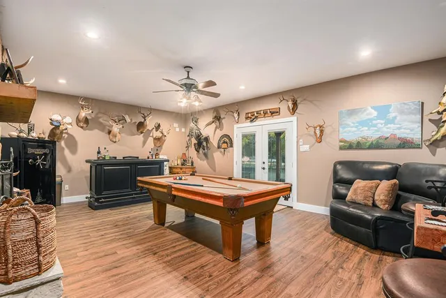 a room with furniture pool table flat screen tv and a large window