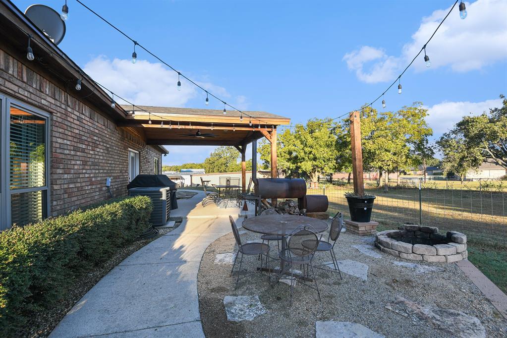 12384 J J Rendon Road Burleson, TX 76028 - Photo 29 of 31 a patio with glass top table and chairs
