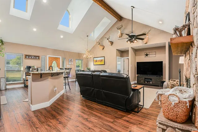 a living room with furniture a flat screen tv and kitchen view