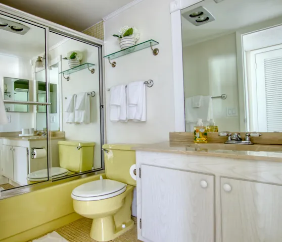a bathroom with a granite countertop toilet sink and mirror