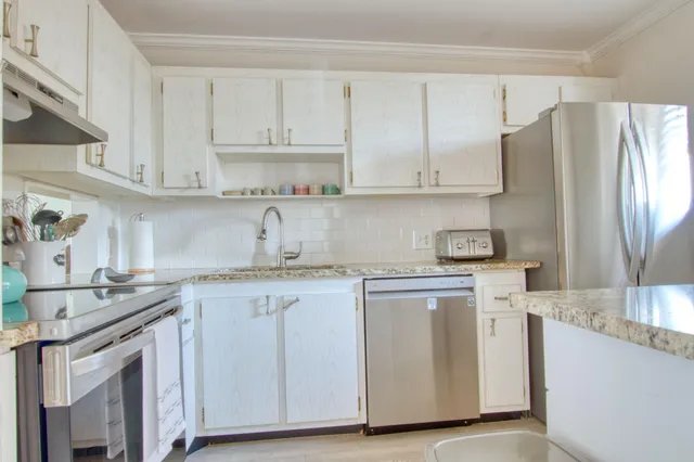a kitchen with stainless steel appliances granite countertop a sink stove and refrigerator