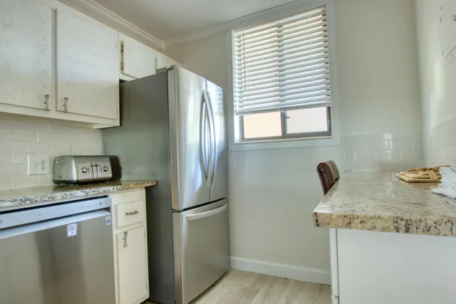 a kitchen with stainless steel appliances granite countertop a refrigerator and a sink