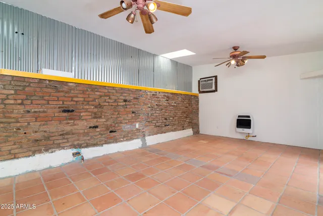 a view of an empty room with a chandelier fan