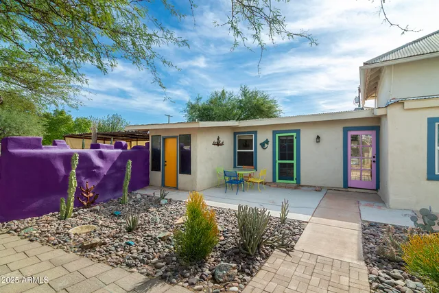 a view of a patio with table and chairs under an umbrella