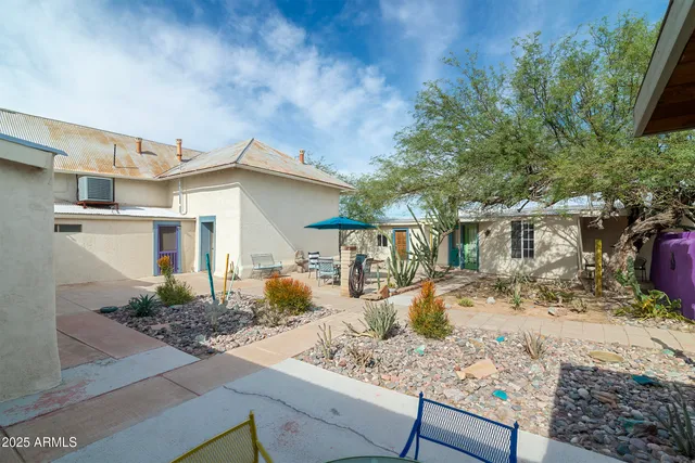 a patio with a table and chairs under an umbrella