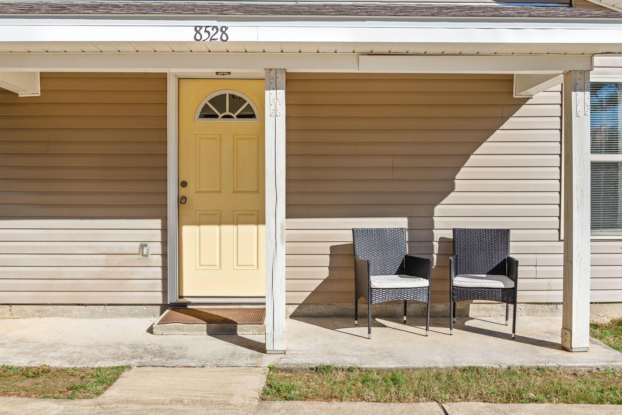 a view of two chairs in the patio