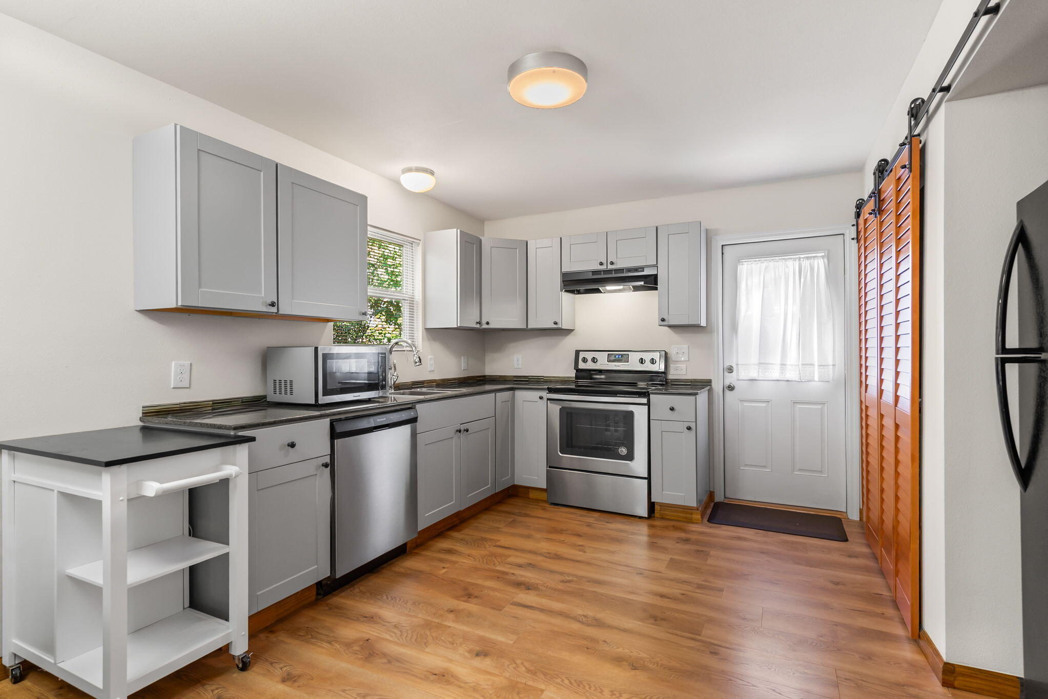 8528 Laredo Street Navarre, FL 32566 - Photo 4 of 16 a kitchen with granite countertop a refrigerator stove top oven and sink