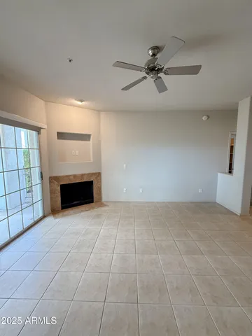 an empty room with windows and fireplace