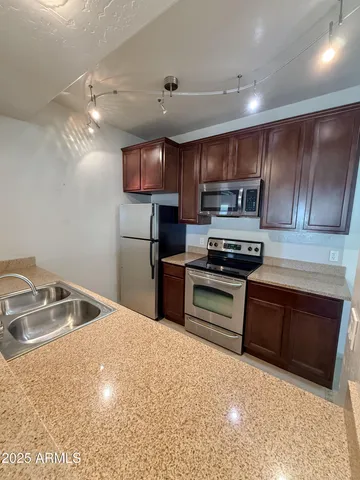 a kitchen with stainless steel appliances granite countertop a sink and a stove