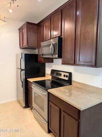 a kitchen with granite countertop cabinets stainless steel appliances and counter space