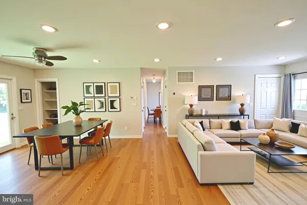 an empty room with wooden floor and a ceiling fan