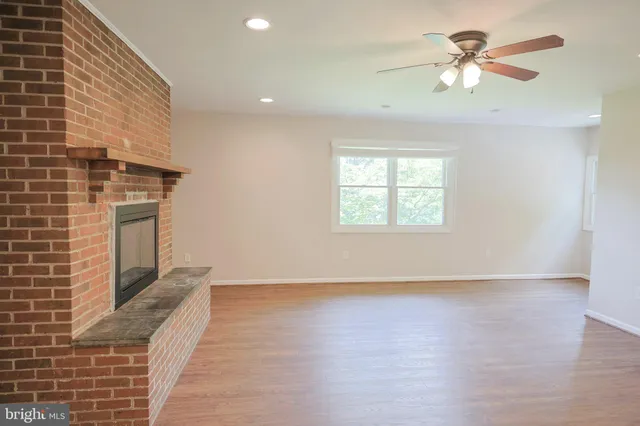an empty room with windows and ceiling fan