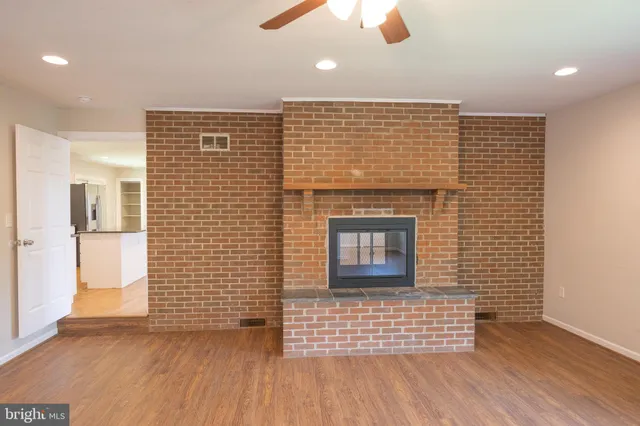 a view of a livingroom with wooden floor and a fireplace