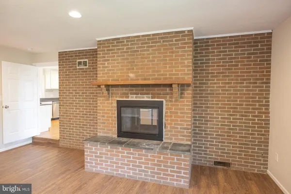 a view of a livingroom with wooden floor and a fireplace