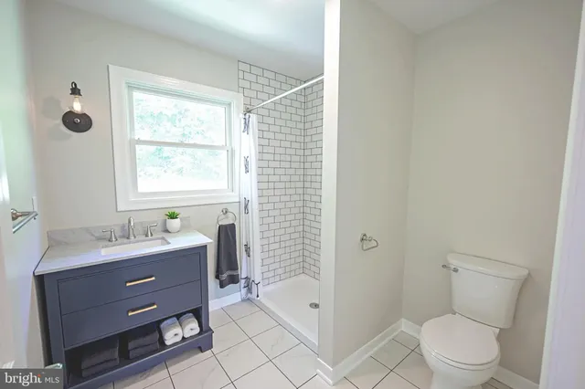 a bathroom with a toilet a sink a mirror a bathtub and shower