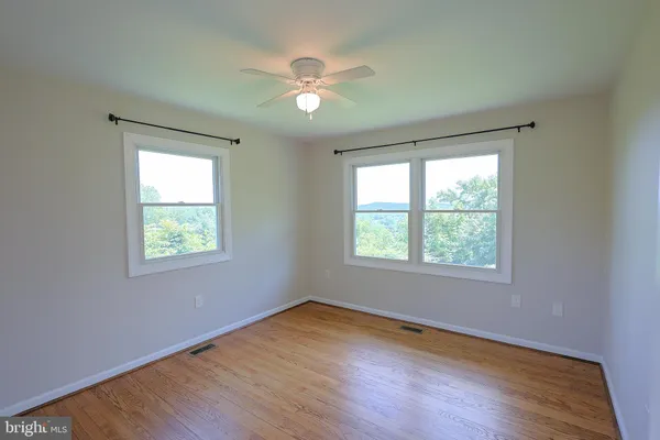 a view of a room with wooden floor and windows