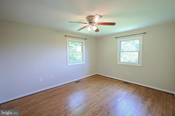 a view of an empty room with wooden floor