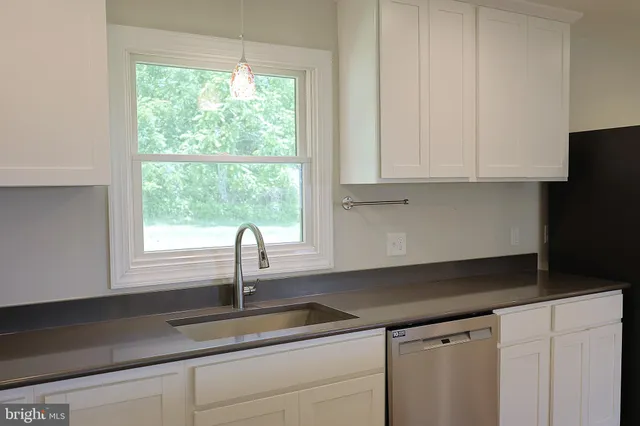 a kitchen with granite countertop a sink and a window