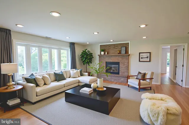 a living room with furniture a large window and a fireplace