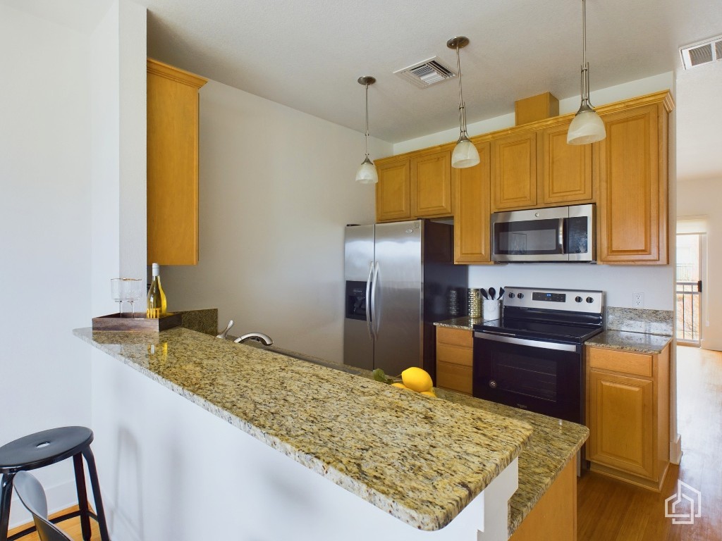 a kitchen with a sink a counter top space cabinets stainless steel appliances and a counter top space