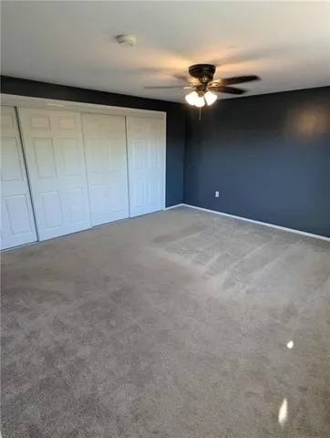 a view of an empty room with a ceiling fan