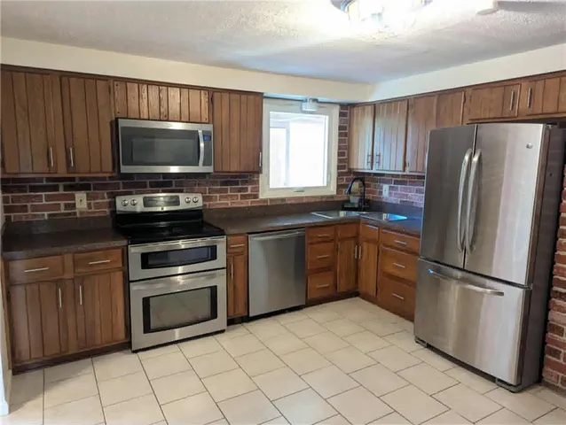 a kitchen with a refrigerator sink and cabinets