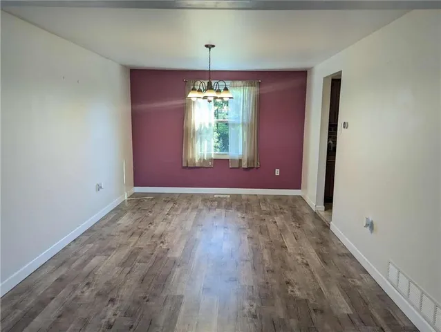 a view of a room with window wooden floor and front door