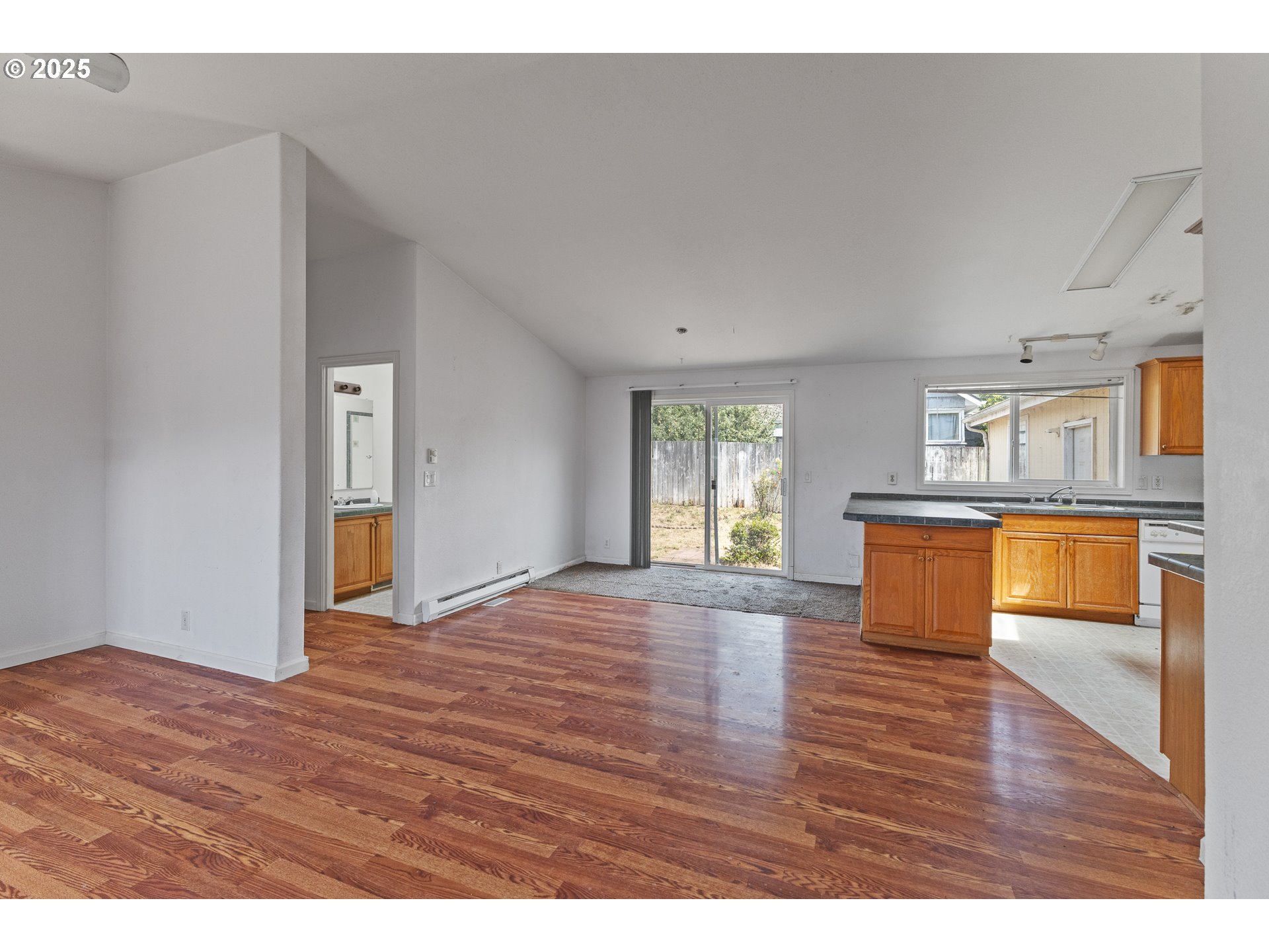 1829 East Willow Street Myrtle Point, OR 97458 - Photo 12 of 37 a view of an empty room and kitchen with wooden floor