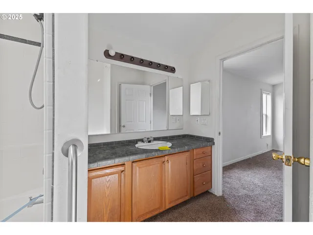 a bathroom with a granite countertop sink and a mirror